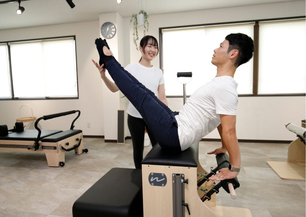 三島市のピラティススタジオで男性がリフォーマーマシンでトレーニングしている様子