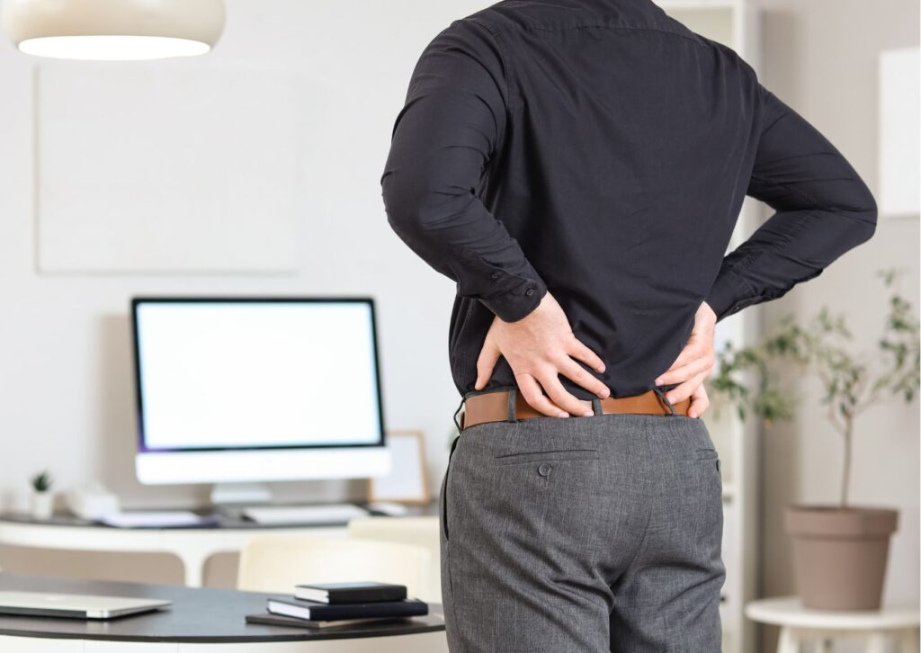 腰痛に悩む男性が腰を押さえているイメージ